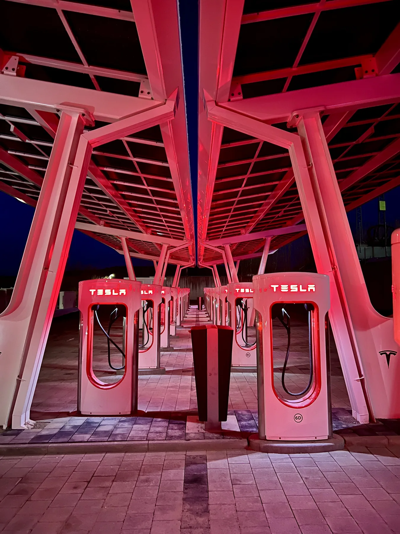 Illuminated Tesla charging park at night